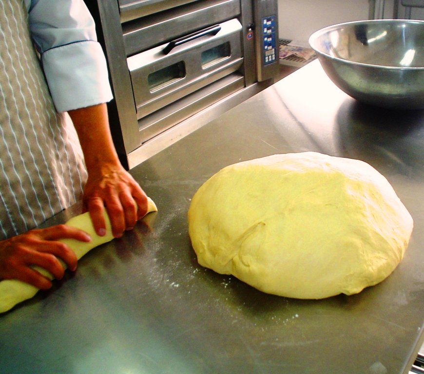 Hacer masa de pan en máquina amasadora. Equipos de panadería